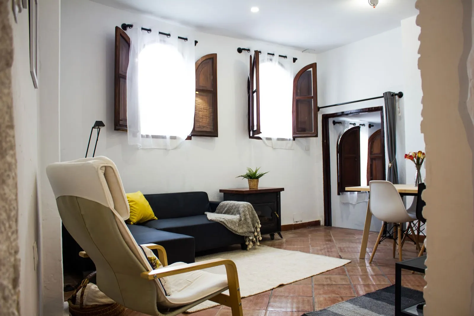 Rincón de lectura del salón junto a las ventanas con contraventanas de madera