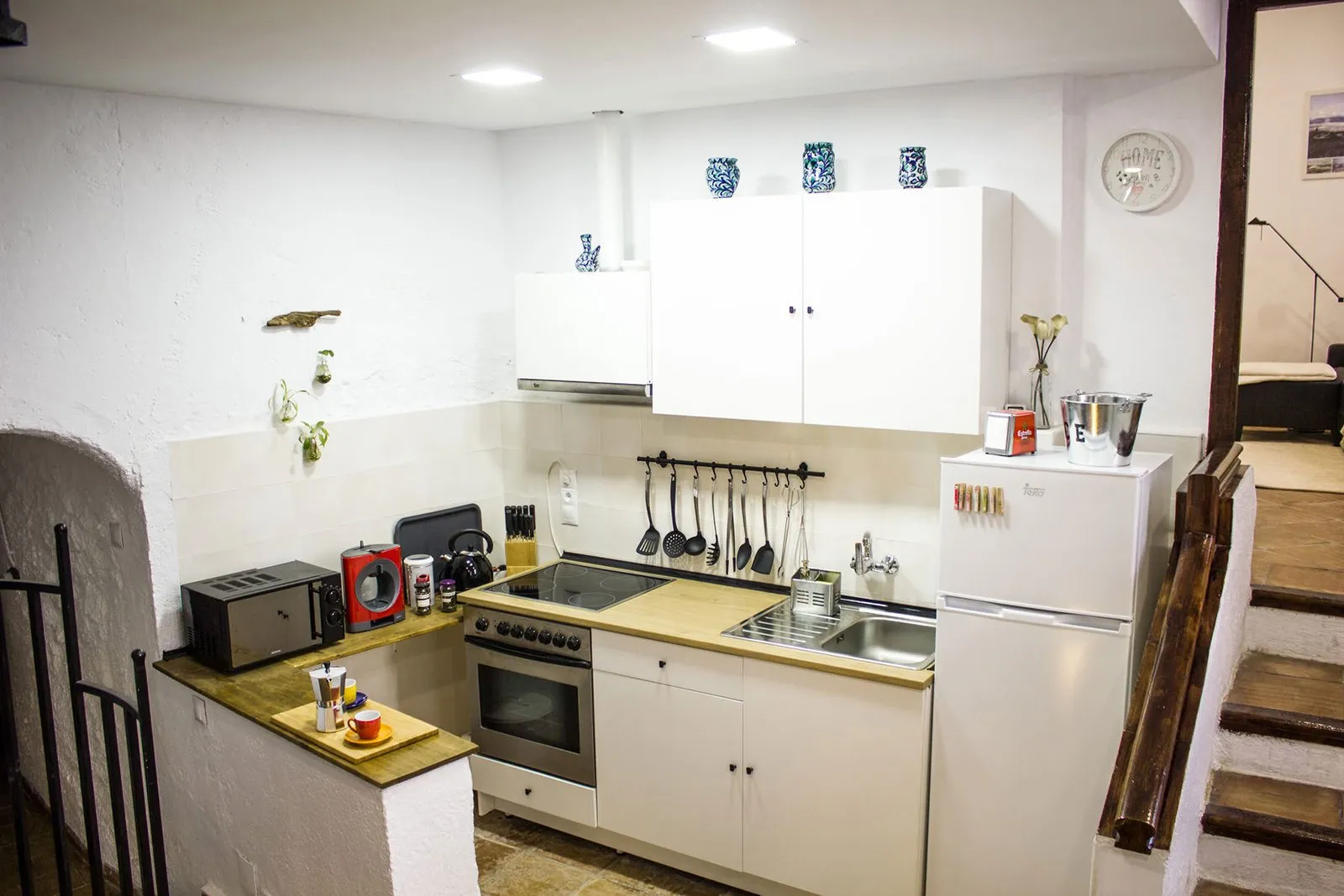 Vista general de la cocina con frigorífico, horno y encimera de madera