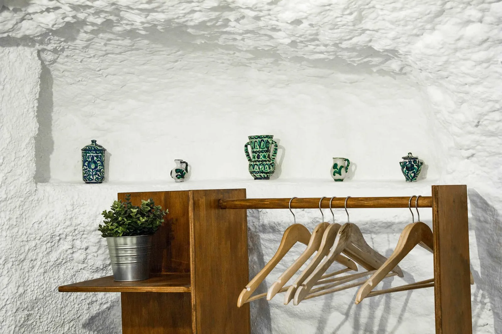 Perchero y estantería de madera con toallas junto a la cama