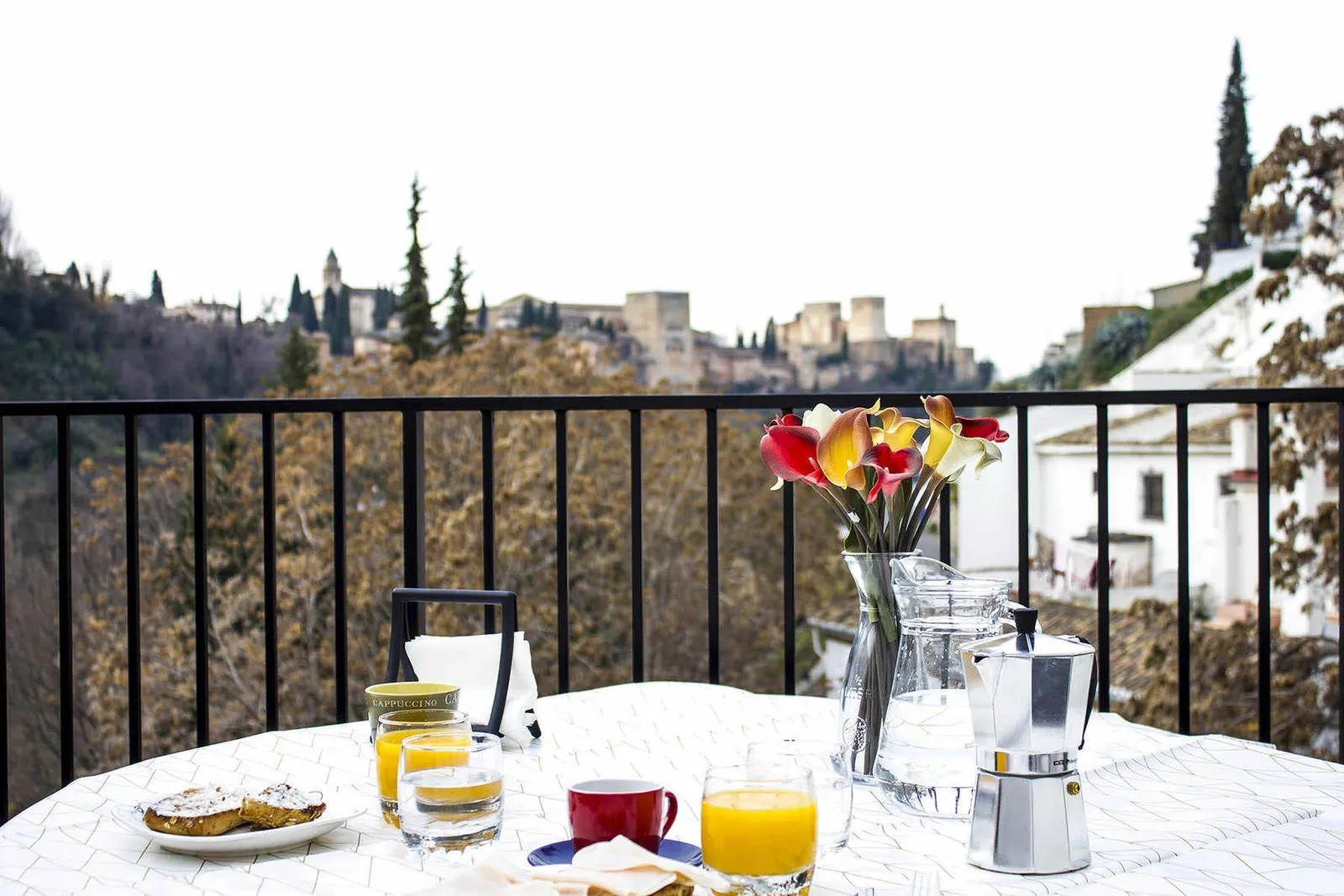 Mesa con desayuno en la terraza frente a la Alhambra