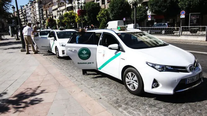Taxi blanco de Granada con la franja verde diagonal en el lateral